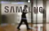 A man walks past the Samsung logo displayed on a glass door at the company's Seocho building in Seoul. [AFP]