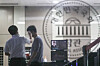 Officials from the National Assembly building management office check a visitor’s temperature at the entrance to the main building of the National Assembly in Yeouido, western Seoul, on Sunday. The National Assembly reopened on Sunday after being shut down for three days for disinfection after a photojournalist who covered the ruling party's leadership meeting on Wednesday tested positive. The National Assembly will open the regular session on Sept. 1. [NEWS1]