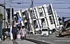 People make their way near a collapsed building due to an earthquake in Wajima, Ishikawa Prefecture, Japan Tuesday. [AP/YONHAP]