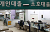 Customers speak with bank employees about loan programs at a bank in central Seoul. [YONHAP]