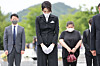 First lady Kim Keon-hee, center, pays her respects at the grave of President Roh Moo-hyun in Bongha Village, Gimhae, in South Gyeongsang on Monday. She is accompanied by a woman, right, who was later identified as a professor and close acquaintance of Kim. [YONHAP]