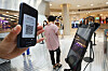 A visitor to the Lotte Department Store main branch in central Seoul checks in with a QR code on Wednesday. The government mandated all large-scale stores keep QR codes or handwritten entry logs from July 30. Lotte Department Store began its testing period on Wednesday. [YONHAP]