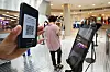 A visitor to the Lotte Department Store main branch in central Seoul checks in with a QR code on Wednesday. The government mandated all large-scale stores keep QR codes or handwritten entry logs from July 30. Lotte Department Store began its testing period on Wednesday. [YONHAP]