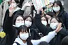 Students wave their hands excitedly at the main entrance to Hyehwa Girls’ High School in Daegu on Thursday afternoon after finishing the College Scholastic Ability Test (CSAT). [NEWS1]