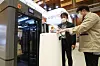 Visitors look at Woojung Bio's sterilization machine for robots that transfer and dispose medical waste at the CPhI Korea 2021 exhibition held at Coex in Gangnam District, southern Seoul, on Monday. Companies specializing in medical devices and equipment attended the event. The exhibition runs through Wednesday. [YONHAP]
