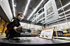 An employee demonstrates how to enter an unmanned Emart24 store in Coex, southern Seoul, by scanning a QR code. [YONHAP]