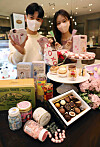 Models hold up sweets at the Shinsegae Department Store Gangnam branch in southern Seoul on Wednesday. The department store's Gangnam branch will carry products from 20 candy and chocolate brands including Candy Me and Drops until White Day on March 14. It is celebrated as a counterpart to Valentine's Day in Korea. [SHINSEGAE DEPARTMENT STORE]
