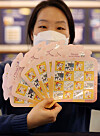 A Korea Post employee holds up next year’s stamps with images of a white ox. The year 2021 is the year of the white ox according to the lunar calendar. The year of the ox is usually considered to be a year of peace and leisure. [YONHAP]