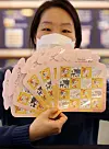 A Korea Post employee holds up next year’s stamps with images of a white ox. The year 2021 is the year of the white ox according to the lunar calendar. The year of the ox is usually considered to be a year of peace and leisure. [YONHAP]
