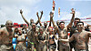 Tourists with mud plastered to their bodies cheer at the Boryeong Mud Festival, which has not been held since the outbreak of the Covid-19 pandemic, at Daecheon Beach in Boryeong, South Chungcheong, on Saturday. The festival began on Saturday and will be held until Aug. 15. [NEWS1]