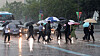 People holding umbrellas cross a main street in downtown Seoul on Thursday as the rainy season begins.  [NEWS1]