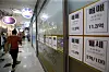 A woman passes by a real estate agency near Gangdong Lotte Castle First apartment complex in Gangdong District, eastern Seoul. No jeonse offers are posted. [JANG JIN-YOUNG]