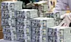 A worker moves stacks of dollar bills at Hana Bank's Counterfeit Notes Response Center in Jung District, central Seoul, on Wednesday.[NEWS1]