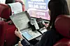 Visitors of the Folk Music Route of Korea look through their tourist kits from inside a bus taking them to locations on the route. [KOREA CULTURAL HERITAGE FOUNDATION]