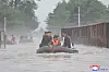 North Korean leader Kim Jong-un, left, rides in a lifeboat to inspect flood-hit areas in North Korea's border city of Sinuiju in this photo carried by Pyongyang's state-controlled Korean Central News Agency on Wednesday. [YONHAP]
