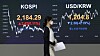 An employee walks pass the screen in the dealing room of KB Kookmin Bank, in the financial district of Yeouido, western Seoul, Monday. [YONHAP]