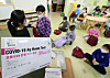 A teacher at a kindergarten in Guro District, western Seoul, distributes Covid-19 home test kits to kindergartners on Tuesday. [YONHAP]