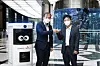 Posco's head of Process & Engineering R&D Center Kim Ki-soo, left, and SK Telecom's head of the Smart Factory division, Choi Nak-hoon, pose for photos after signing a business agreement on Friday. Standing to the left of Kim is Keemi, SK Telecom's automated cleaning and disinfecting machine. [SK TELECOM]