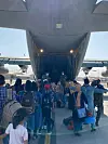 Afghans bound for Korea board a Korean Air Force transport plane at the Kabul airport Tuesday, local time. The Korean government flew three military aircraft to Pakistan earlier this week to airlift 390 Afghan evacuees, including 100 children. [FOREIGN MINISTRY]