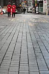 Seoul city government tour guides wait for tourists on the empty streets of Myeong-dong on Tuesday. As the Covid-19 pandemic rages on, once popular destinations such as Myeong-dong have been hit hard. [YONHAP]
