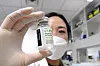 A researcher at Celltrion holds up a bottle of the Covid-19 treatment candidate, CT-P59, at the company's factory in Incheon. [YONHAP]