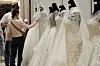 A couple looks at a wedding dress at Coex Mall in Samseong-dong, southern Seoul, on Sunday. The 54th edition of the two-day wedding fair was hosted by Weddex Wedding, a wedding consulting firm. [YONHAP]