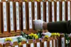 A bereaved family member of the victims of Sunday’s Jeju Air crash touches one of the memorial plaques with the names of the victims at a memorial altar set up in Muan Sports Complex in Muan, South Jeolla, on Monday. [JOONGANG ILBO]