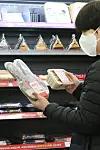 A person looks at a rabbit-shaped lunch box meal at a CU convenience store in BGF Retail headquarters building in Gangnam District, southern Seoul, Monday. Local retailers are marketing rabbit-themed products in celebration of 2023, the year of the rabbit according to the Chinese zodiac. [YONHAP]