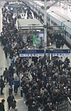 Passengers crowd around a staircase on a railway platform after disembarking from a train at Seoul Station on Feb. 12, as travel surges ahead of the five-day Lunar New Year holiday period that begins on Feb. 14.