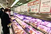 A customer shops for packs of samgyeopsal, or pork belly, at Emart's Yongsan branch in central Seoul, on Wednesday. Discount marts are running promotions on pork belly ahead of March 3, popularly known in Korea as Samgyeopsal Day. [YONHAP]