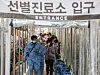 People wait in a long line to get tested for Covid-19 at a testing center in Gwanak District, southern Seoul, on Wednesday morning, when the country's daily new infections surged to a record 2,223. [YONHAP]