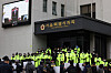 TBS employees watch a session of the Seoul Metropolitan Council being broadcasted outside its building on Tuesday. The session passed a bill Tuesday that will scrap Seoul city government's funding for TBS starting in 2024. [YONHAP]
