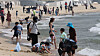 People cool themselves off on Haeundae Beach in Busan on Sunday as average temperatures reach higher than usual across the country such as 22 degrees Celsius (72 degrees Farenheit) in Busan, 24 degrees Celsius in Seoul and 30 degrees Celsius in Daegu, North Gyeongsang. [SONG BONG-GEUN]