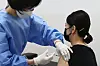 An airline crewmember receives an AstraZeneca shot in a hospital in Gangseo District, Seoul on Monday, as the country rolls out vaccinations for care workers and airline crew. [YONHAP]
