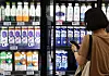 A shopper selects milk at a large supermarket in Seoul on July 27. [YONHAP]