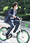 New opposition leader Lee Jun-seok wears a backpack and rides a bike to report to work in the National Assembly on June 13. [OH JONG-TAEK]