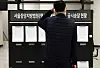 A visitor reads a bulletin board at the Seoul Central District Court in Seocho District, southern Seoul, Monday. The Supreme Court’s National Court Administration earlier that day strongly recommended all court trials be delayed so as not to fall to fall between Tuesday and Jan. 11 except for urgent cases. [NEWS1]