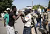 A Haitian police officer tries to subdue a man who had crossed without authorization into the Binational Market and who was expelled by the Dominican military to his country, in the border area of Dajabon, Dominican Republic, on Sunday. [EPA/YONHAP]