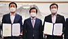 Rep. Kim Gi-hyeon, floor leader of the main opposition People Power Party, left, and Rep. Yun Ho-jung, floor leader of the ruling Democratic Party, right, hold agreements at the office of National Assembly speaker Park Byeong-seug, center, on Friday. They struck a deal that day that the ruling party will end its control of all 18 National Assembly committees and allow the opposition to chair seven in the final two years of the 21st National Assembly. [YONHAP]