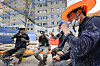 Workers take a break while enjoying popsicles under a shade at an SK apartment construction site in Incheon on Tuesday. Officials overseeing the construction say that they have taken steps to help workers beat the heat, including installing cooling systems and taking turns having breaks. [YONHAP]