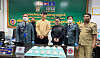 Two handcuffed Korean nationals take a photo with Cambodian border control and customs officials after the crackdown at Phnom Penh International Airport. [KHMER TIMES]
