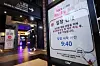 A sign posted in front of a movie theater which requires audiences to check in using a smart attendance system and to measure their temperatures. [YONHAP]