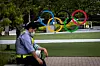 A security guard takes a break in front of the Olympic rings in Tokyo on June 3, 2021. [AFP]