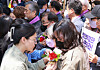 Participants of a memorial ceremony held at Seoul Square in central Seoul on Monday, Parent's Day in Korea, pin carnations on the jackets of parents who lost their child during the Oct. 29 Itaewon crowd crush last year. The families of the victims will hold rallies near Yeouido in western Seoul until May 16, calling on the government to enact a special law to punish those responsible and to establish preventive measures for future accidents. [YONHAP]