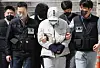 A suspect surnamed Kim, in white, who was in charge of blackmailing the parents of students who consumed drug drinks, enters the Seoul Central District Court in southern Seoul on Monday. [YONHAP]