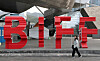 A passerby walks across the Busan International Film Festival (BIFF) logo in front of the Busan Cinema Center in Haeundae District, eastern Busan, on May 24. [NEWS1]