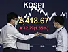 Two employees fist-bump in front of the screen with the Kospi close at a dealing room at KB Kookmin Bank in the financial district of Yeouido, western Seoul, Tuesday. [NEWS1]