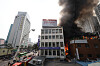 Firefighters put out the fire that broke through an old building near Sewoon Plaza in Jung District, central Seoul, on May 28. [YONHAP]