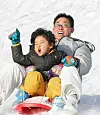 Visitors at Seoulland in Gwacheon, Gyeonggi, enjoy sledding down a slope at the theme park. [LIM HYUN-DONG]