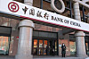 A pedestrian stands beside a Bank of China branch in Beijing. [EPA/YONHAP]